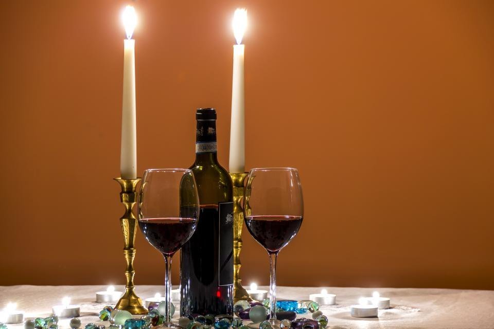 Candles and red wine on a dinner table